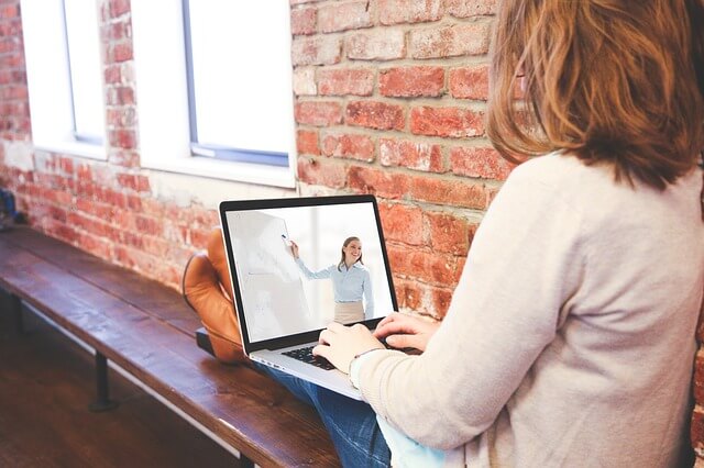 Une femme qui suit un cours en ligne sur son ordinateur portable